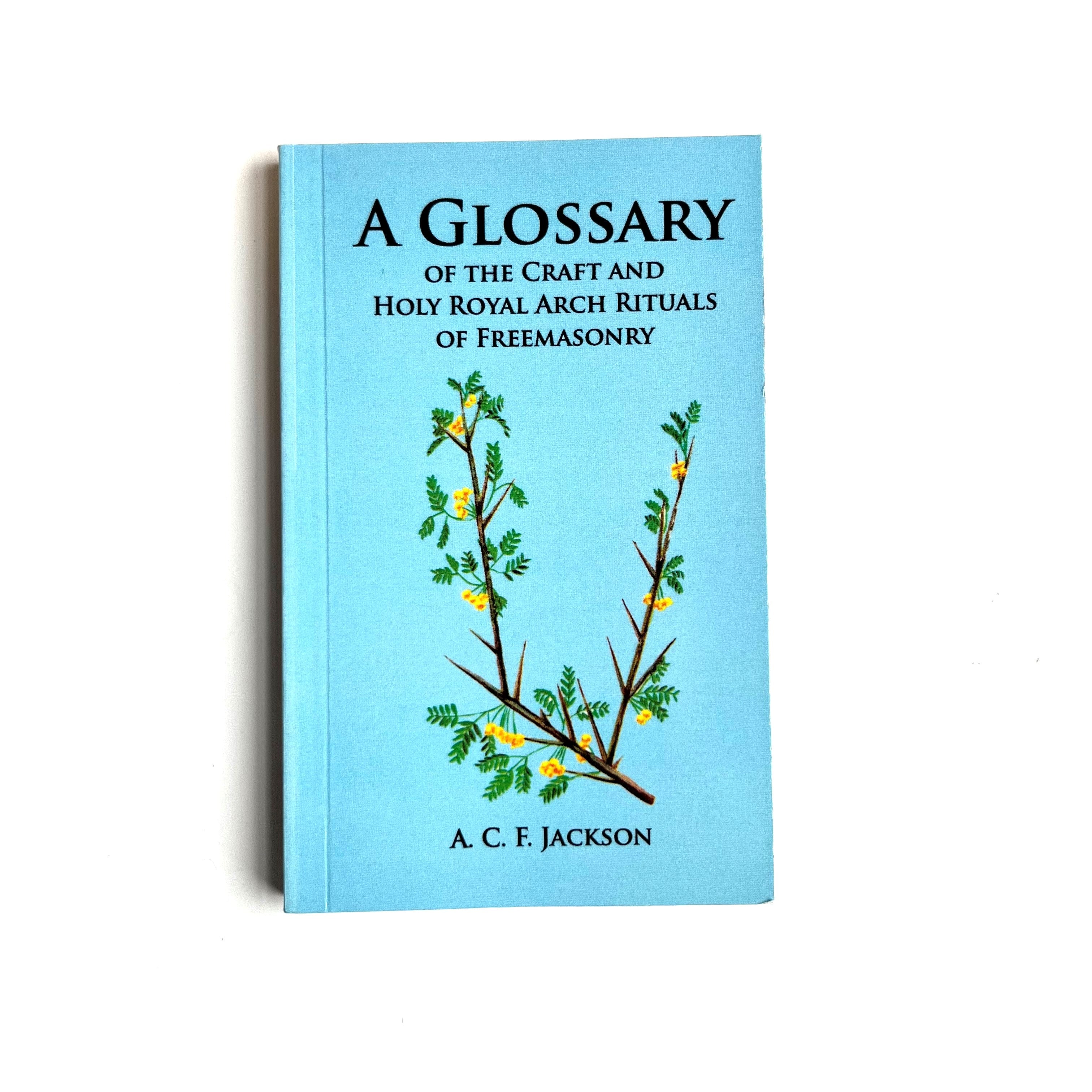 A blue book cover with a title 'A Glossary of the Craft and Holy Royal Arch Rituals of Freemasonry' featuring a graphical design with green leaves and a branch.