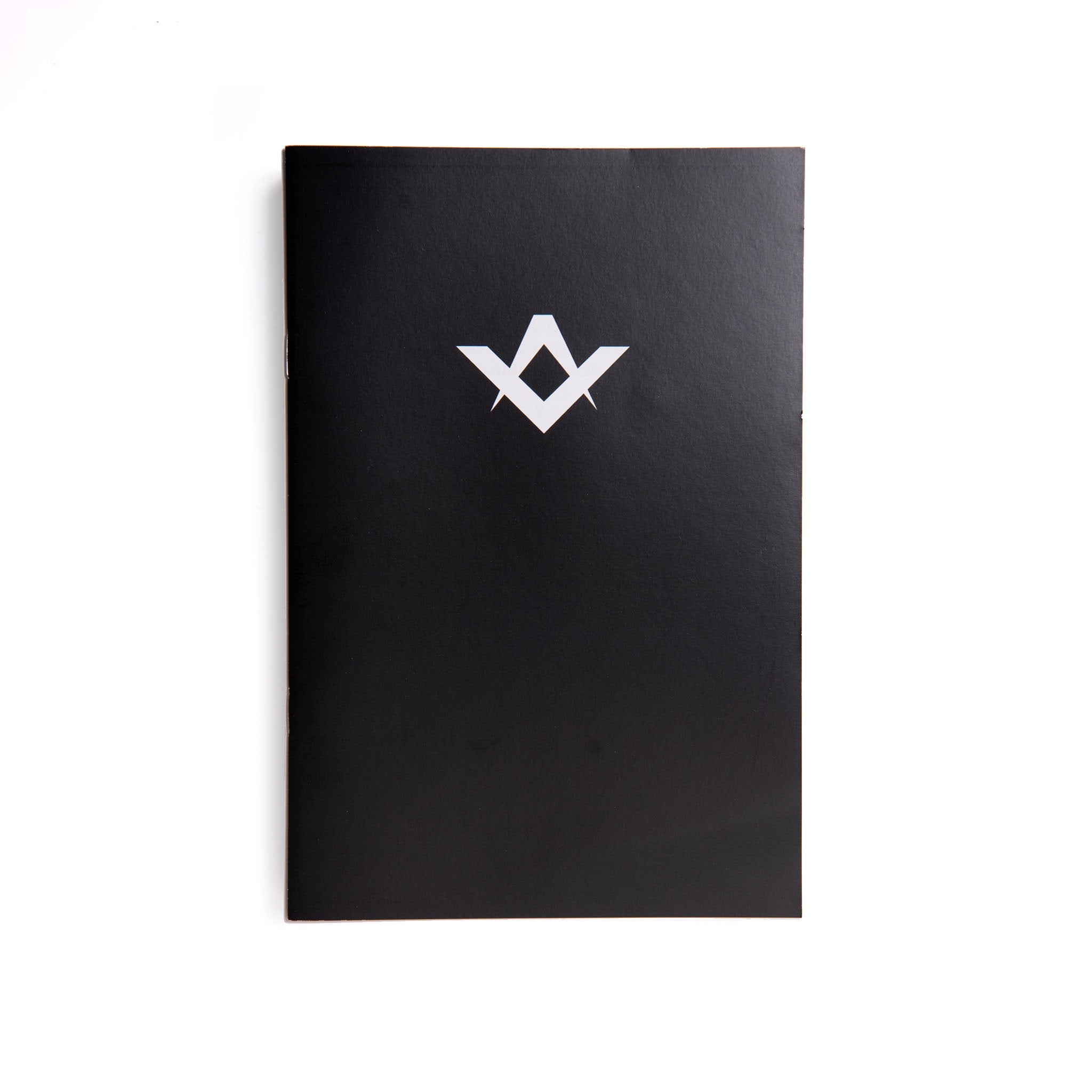 A Emulation Inner Workings black book with a white Masonic symbol on the cover.