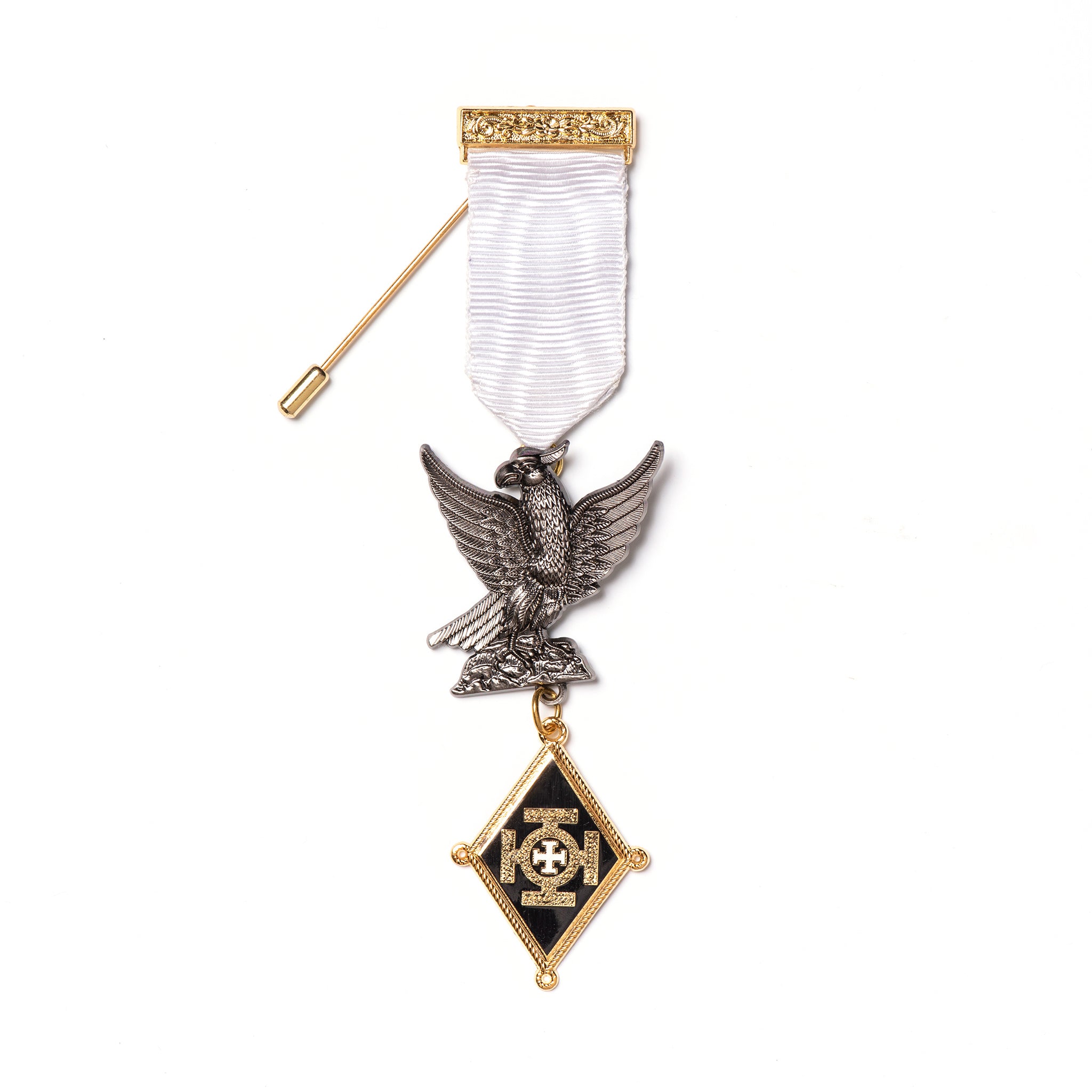 A Knight of the Holy Sepulchre Companion Breast Jewel with a white ribbon, featuring metalwork including an eagle and a shield, with a black and gold emblem at the center and a stickpin on the back.