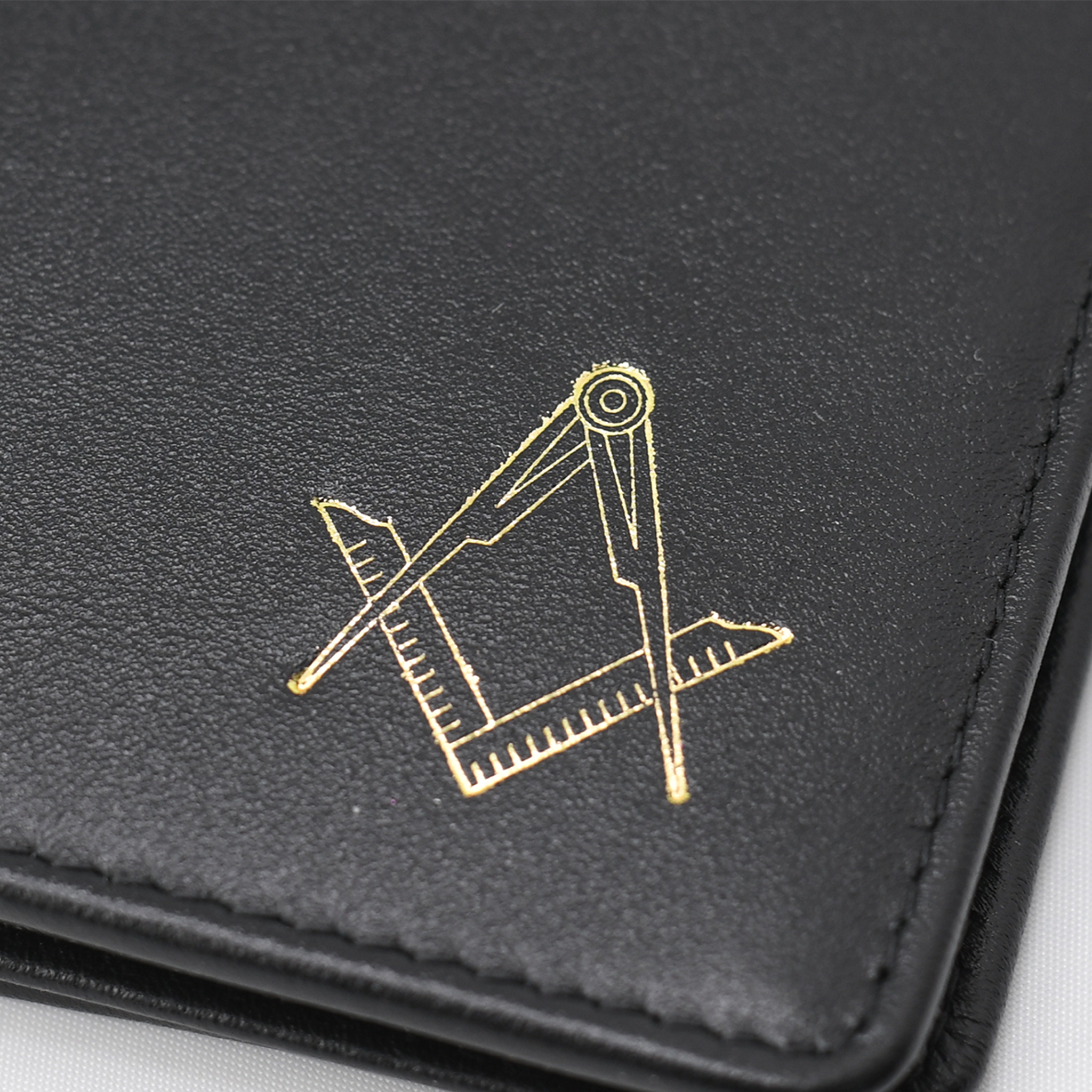 Premium Black leather card wallet with stitched edges, featuring a gold Masonic square-and-compass emblem. Close up detailed shot
