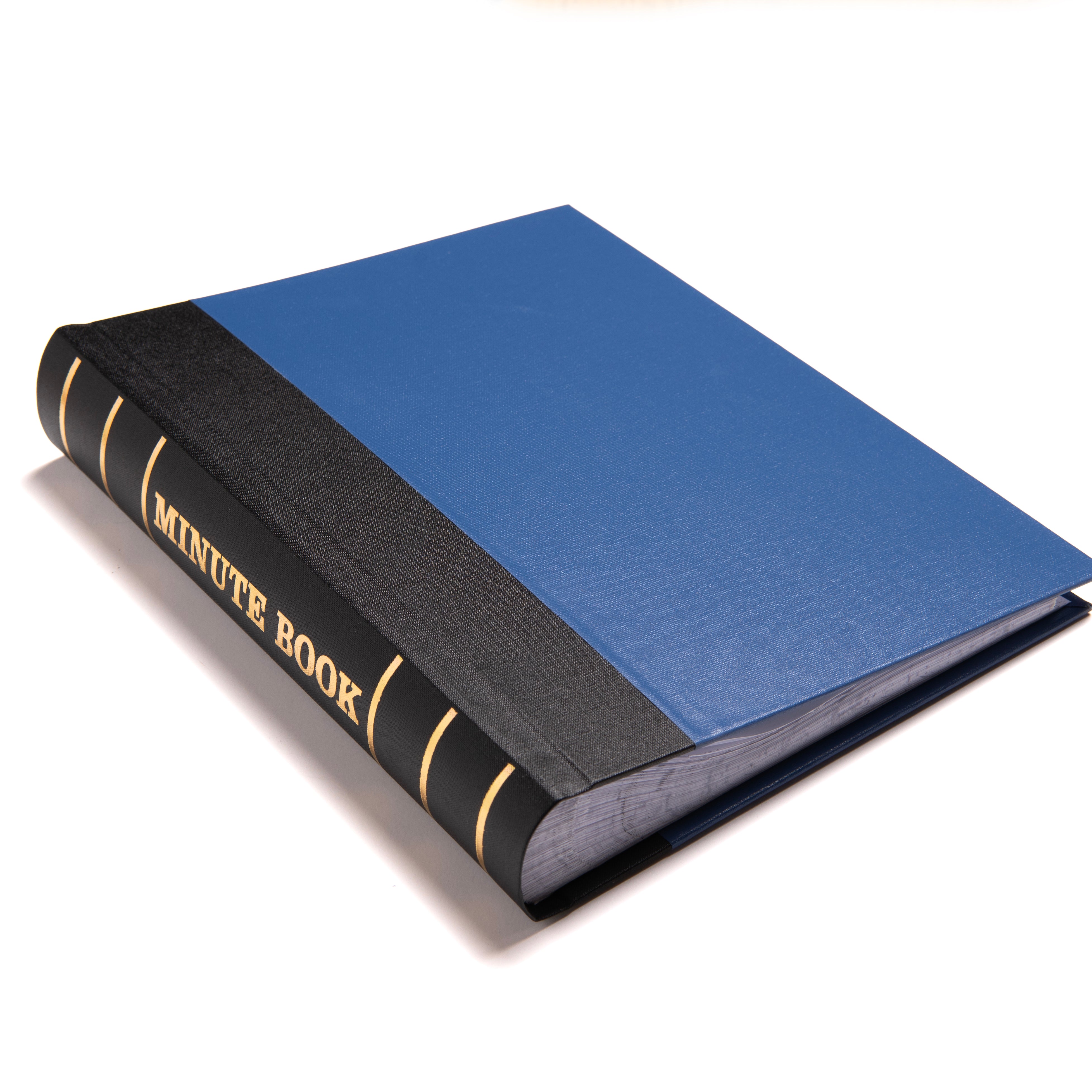 A bound Masonic minute book with a blue and black cover, the title 'MINUTE BOOK' is visible on the spine.