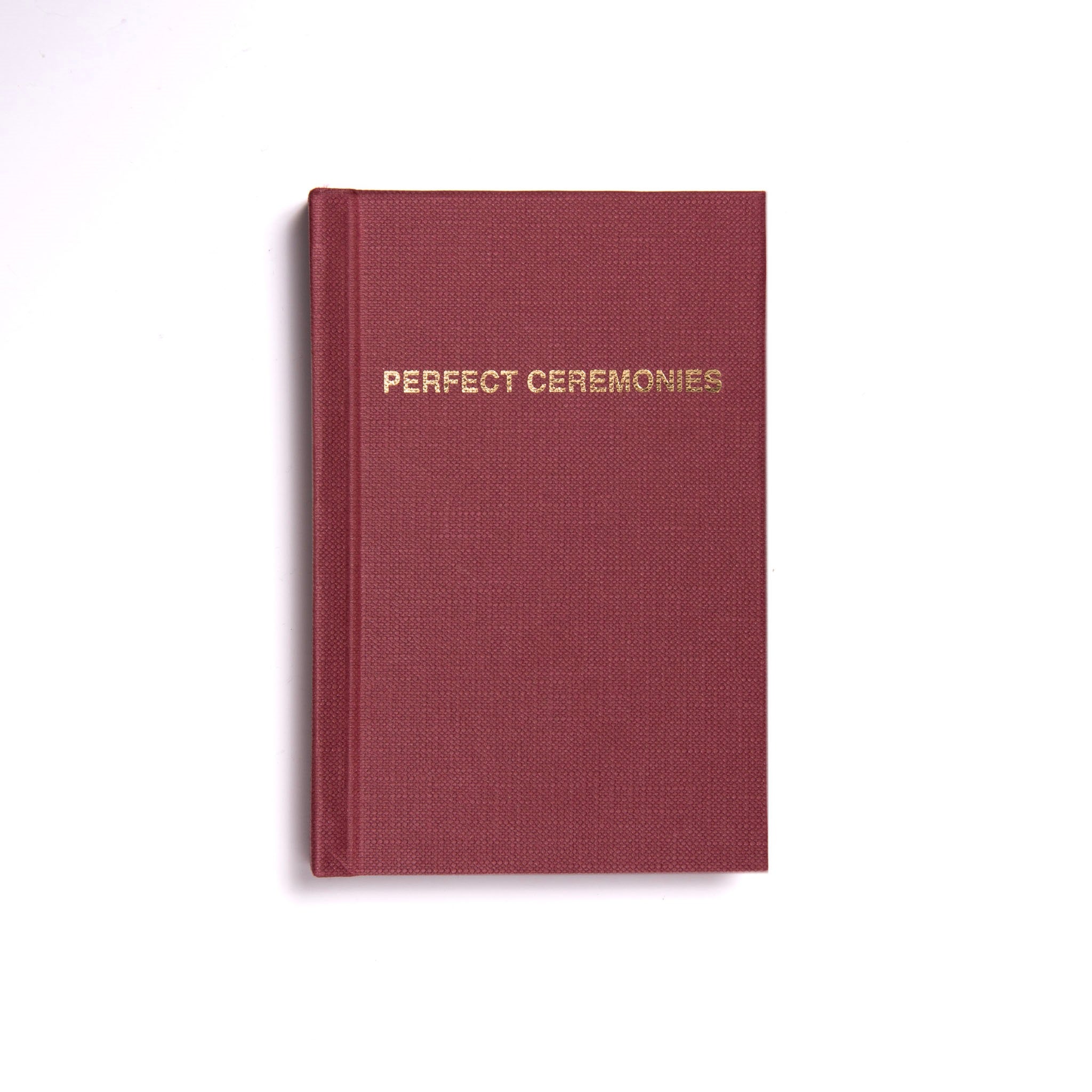 A hardback Masonic ritual book with a maroon cover and the title 'Perfect Ceremonies' embossed in gold lettering on the front.