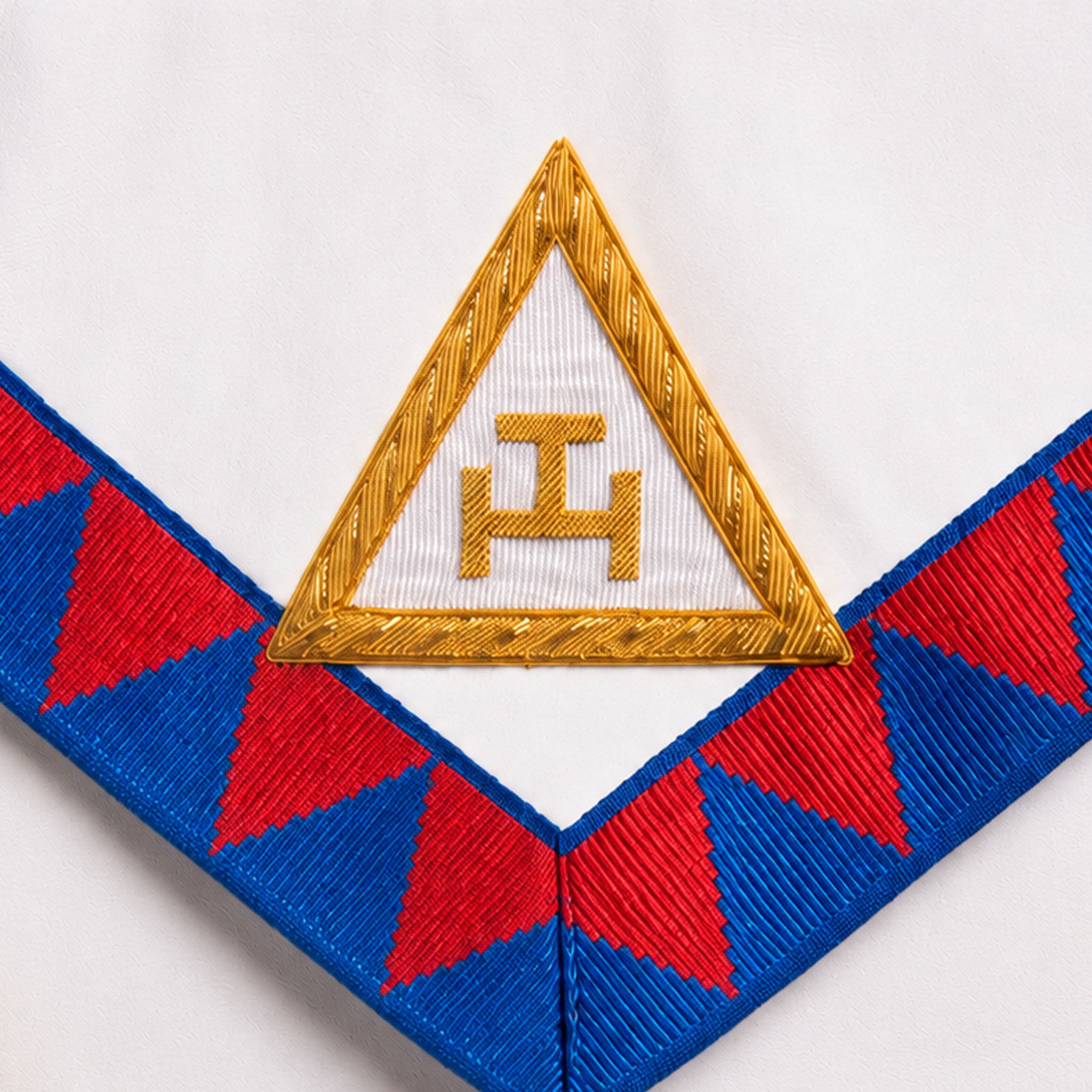 UGLE-approved Masonic Royal Arch Companion apron featuring a white front with a gold emblem, red and blue geometric patterns on the sides. Close up image of the Royal Arch symbol
