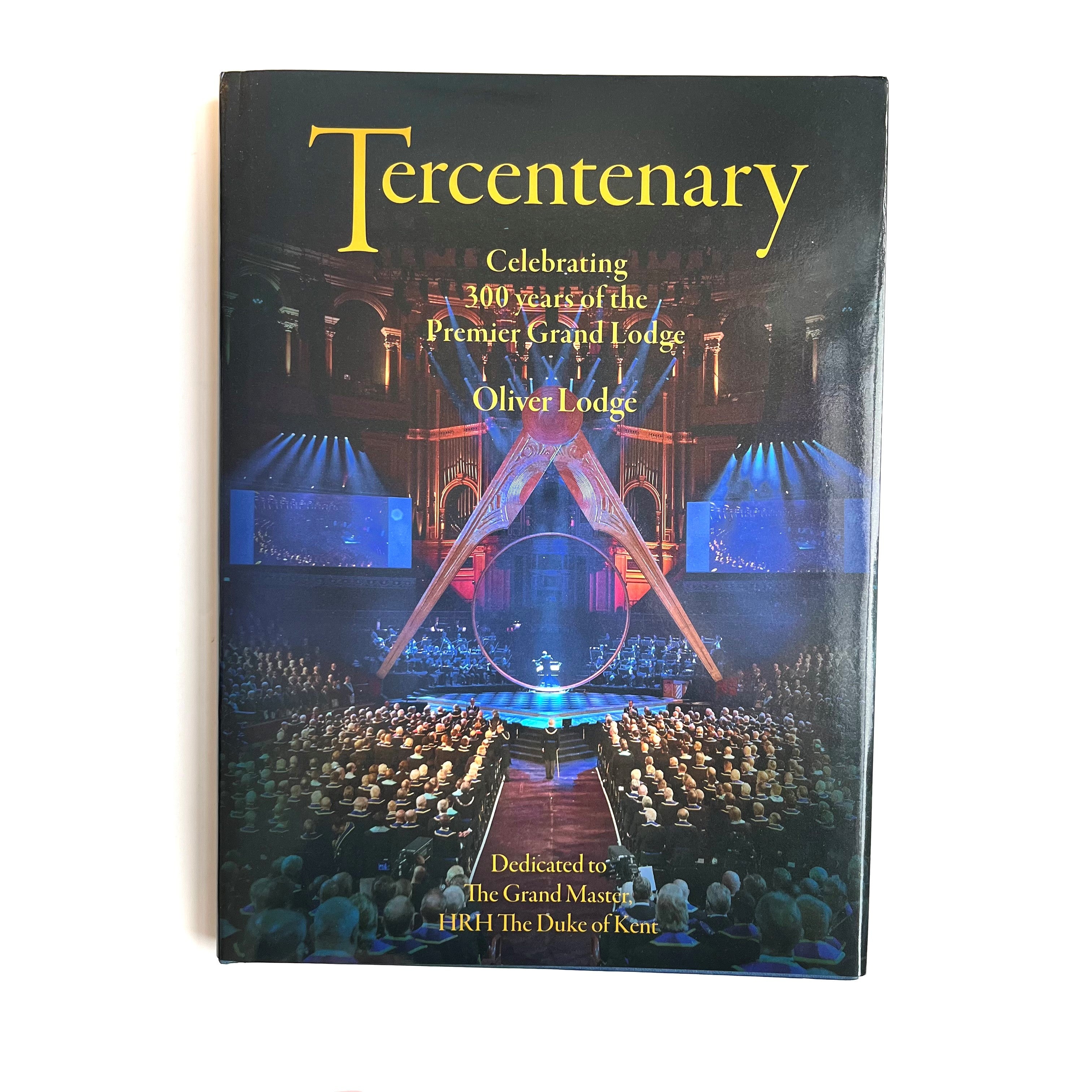 A cover of the book titled 'Tercentenary: Celebrating 300 years of the Premier Grand Lodge' showing an image of a grand ceremony with an audience and stage setup.