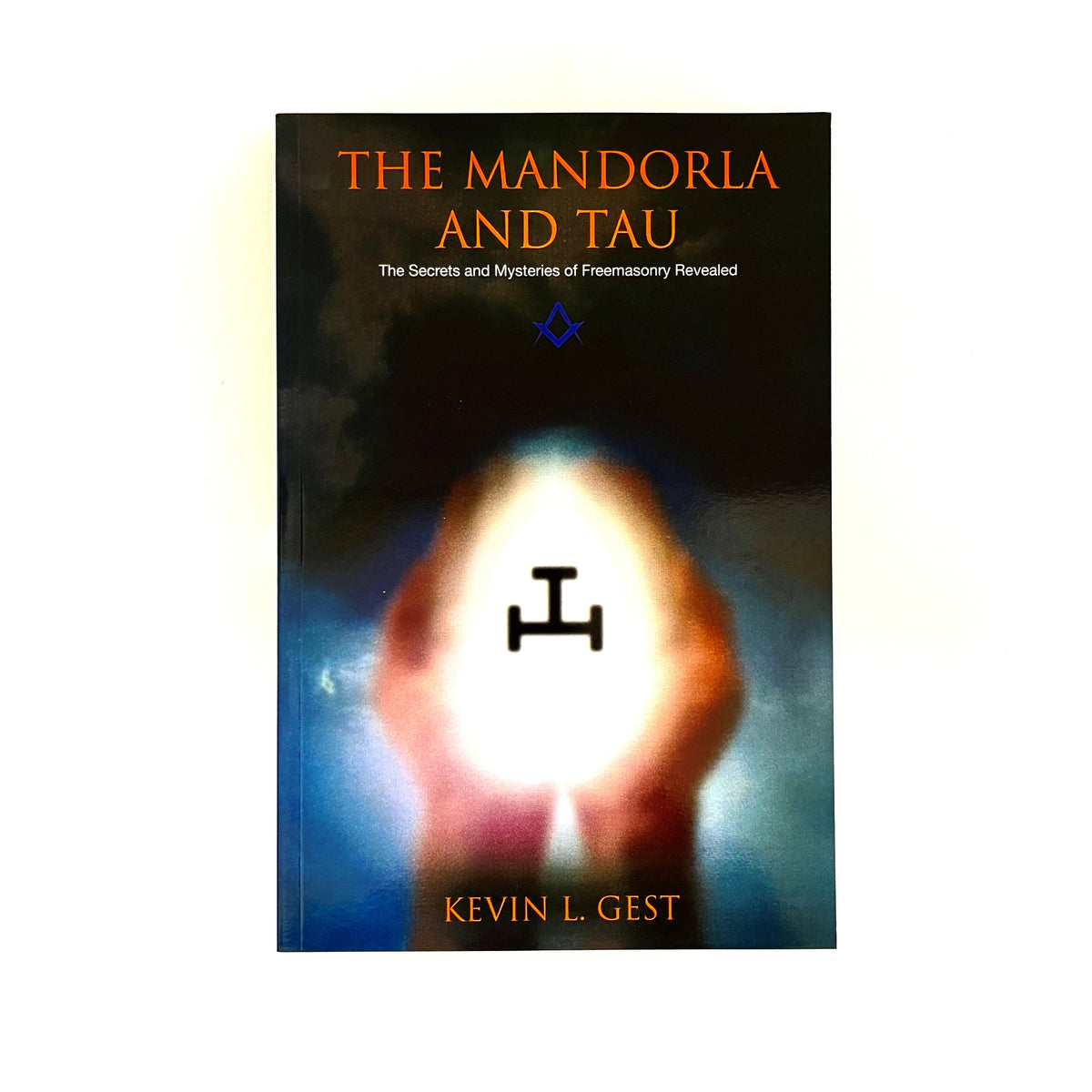 The image features the cover of a book titled "The Mandorla and Tau: The Secrets and Mysteries of Freemasonry Revealed" by Kevin L. Gest.