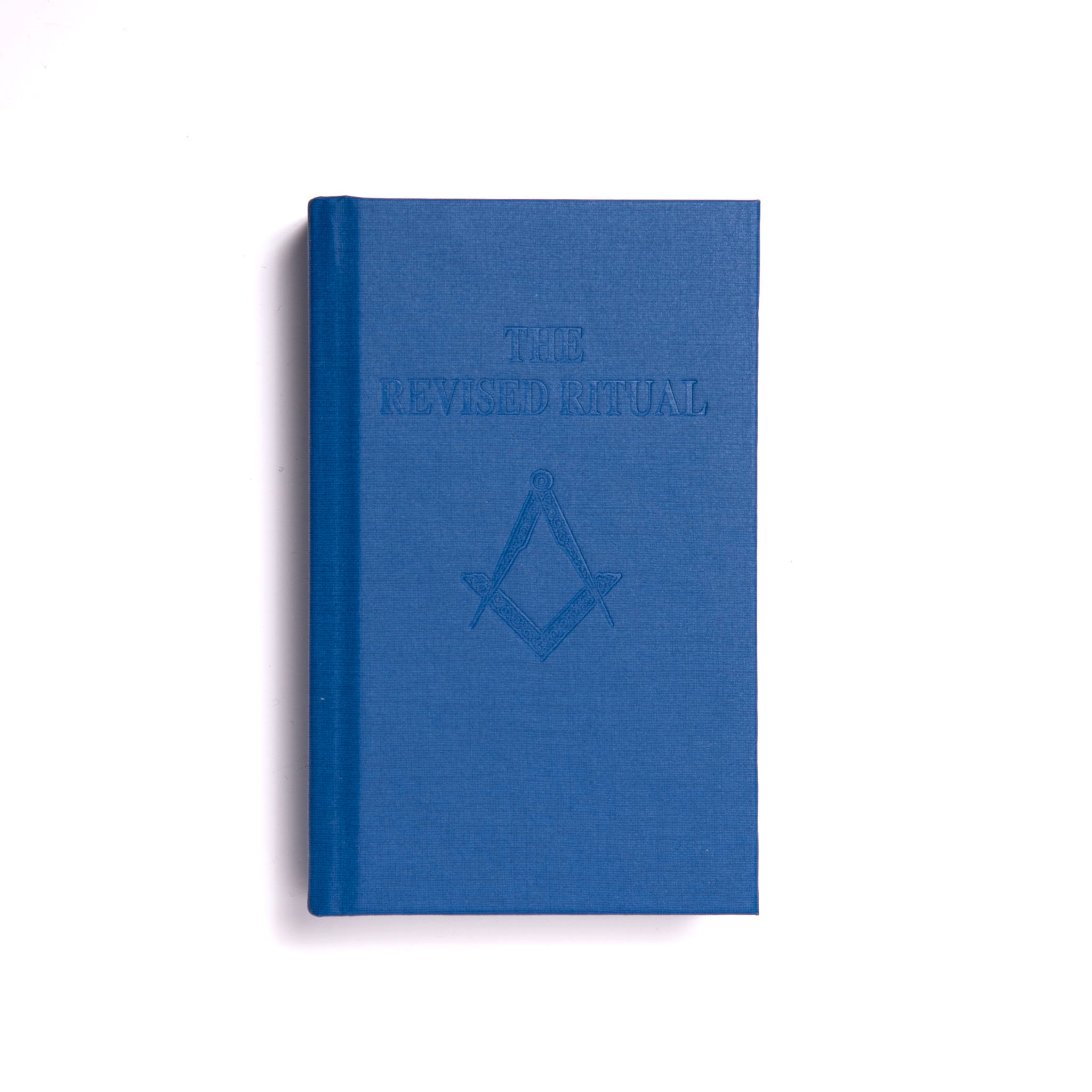 A blue book with an embossed emblem on the cover, titled 'The Revised Ritual'.