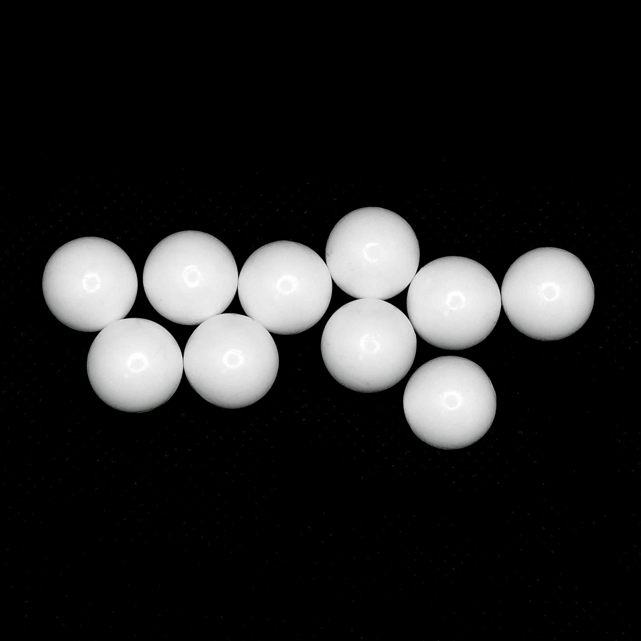 A collection of 10 Masonic Lodge white ballot balls against a black background.