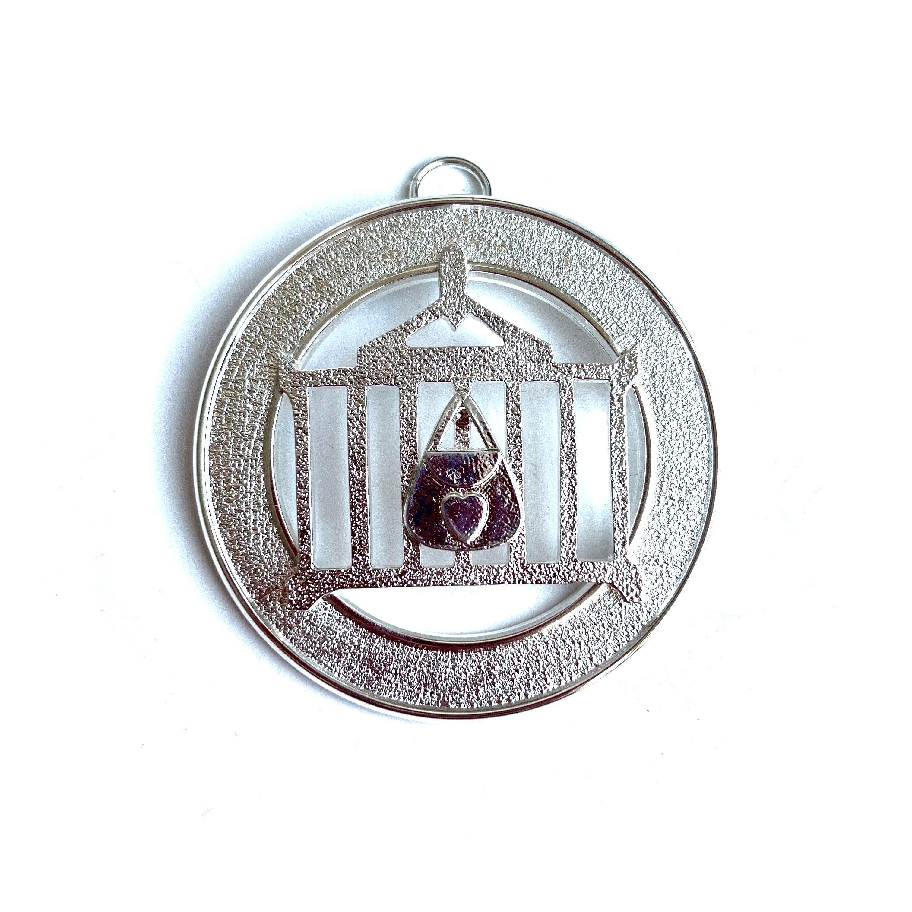 Allied Officer's Collar Jewel - Almoner, silver coloured on a white background.