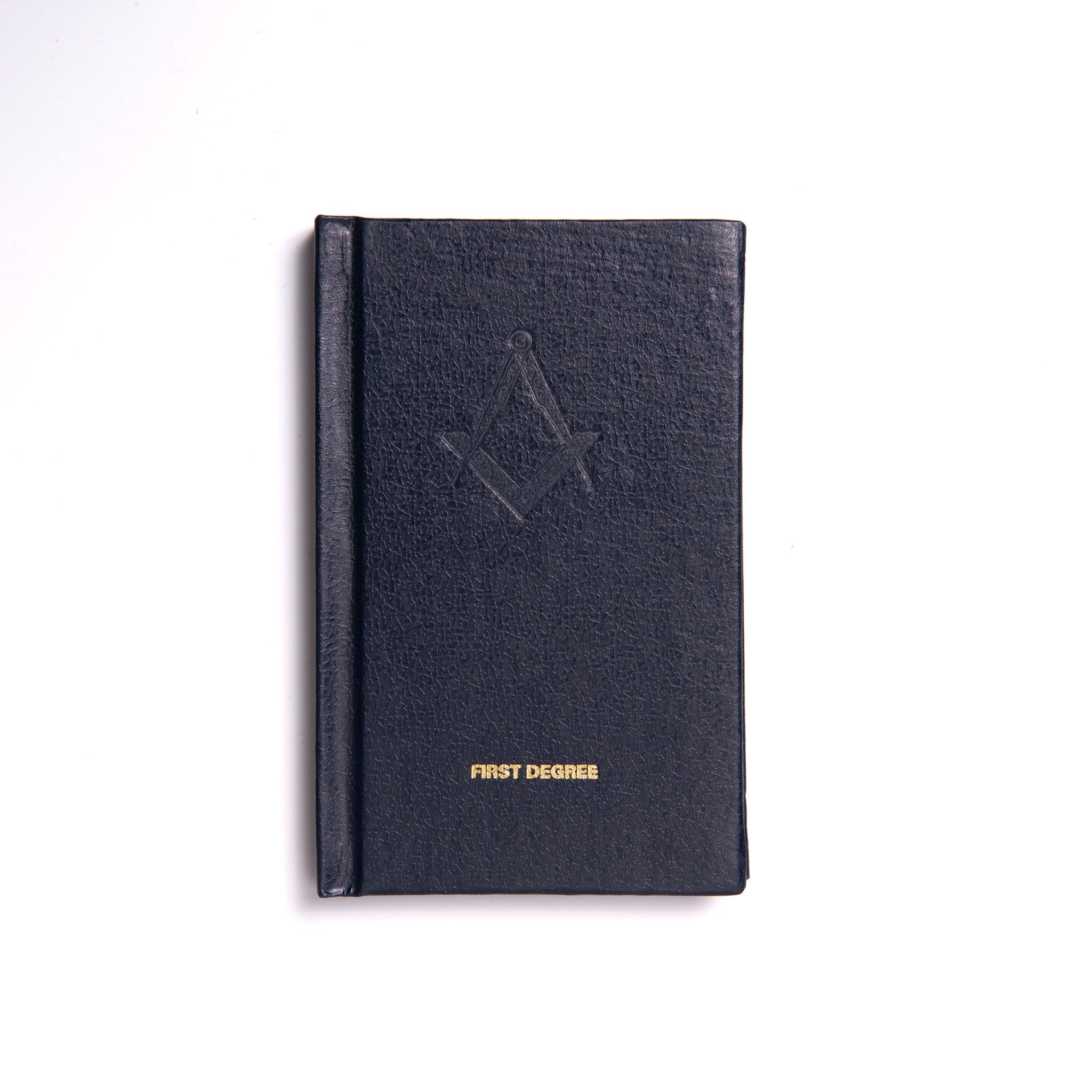 A Masonic Emulation 1st Degree closed hardcover book with a leather binding and embossed lettering on the cover, titled 'FIRST DEGREE'.