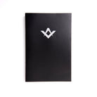 A Emulation Inner Workings black book with a white Masonic symbol on the cover.