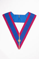 A blue and pink striped Mark Grand Rank Collar with a golden emblem in the center, displayed against a white background.