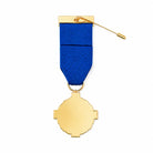 A gold-coloured medal with a blue ribbon and a small gold pin attached, shown on a plain white background.