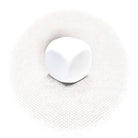 A single white Masonic cube placed on a textured surface.