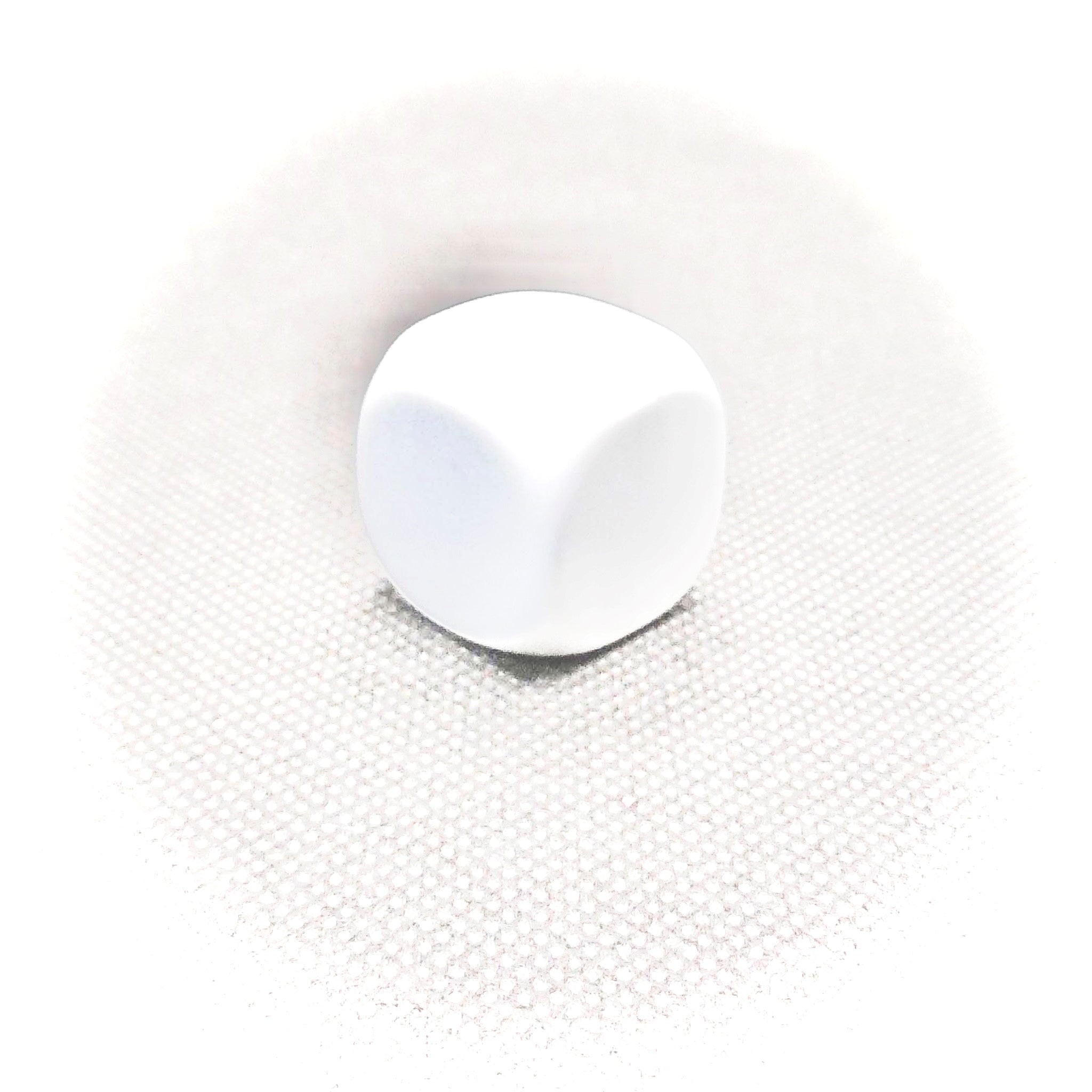 A single white Masonic cube placed on a textured surface.