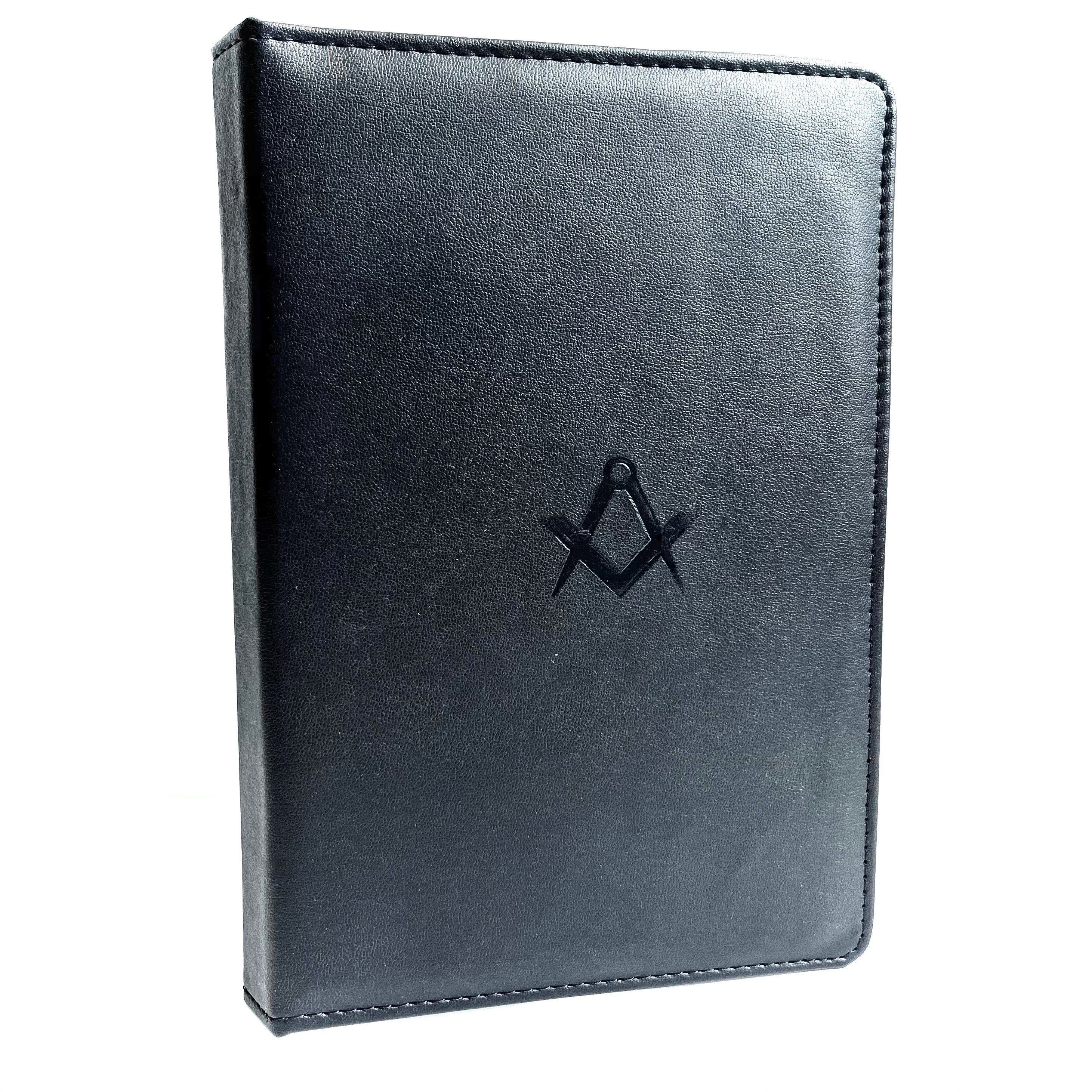 A black leather ritual book cover featuring a square and compasses emblem embossed on the front.