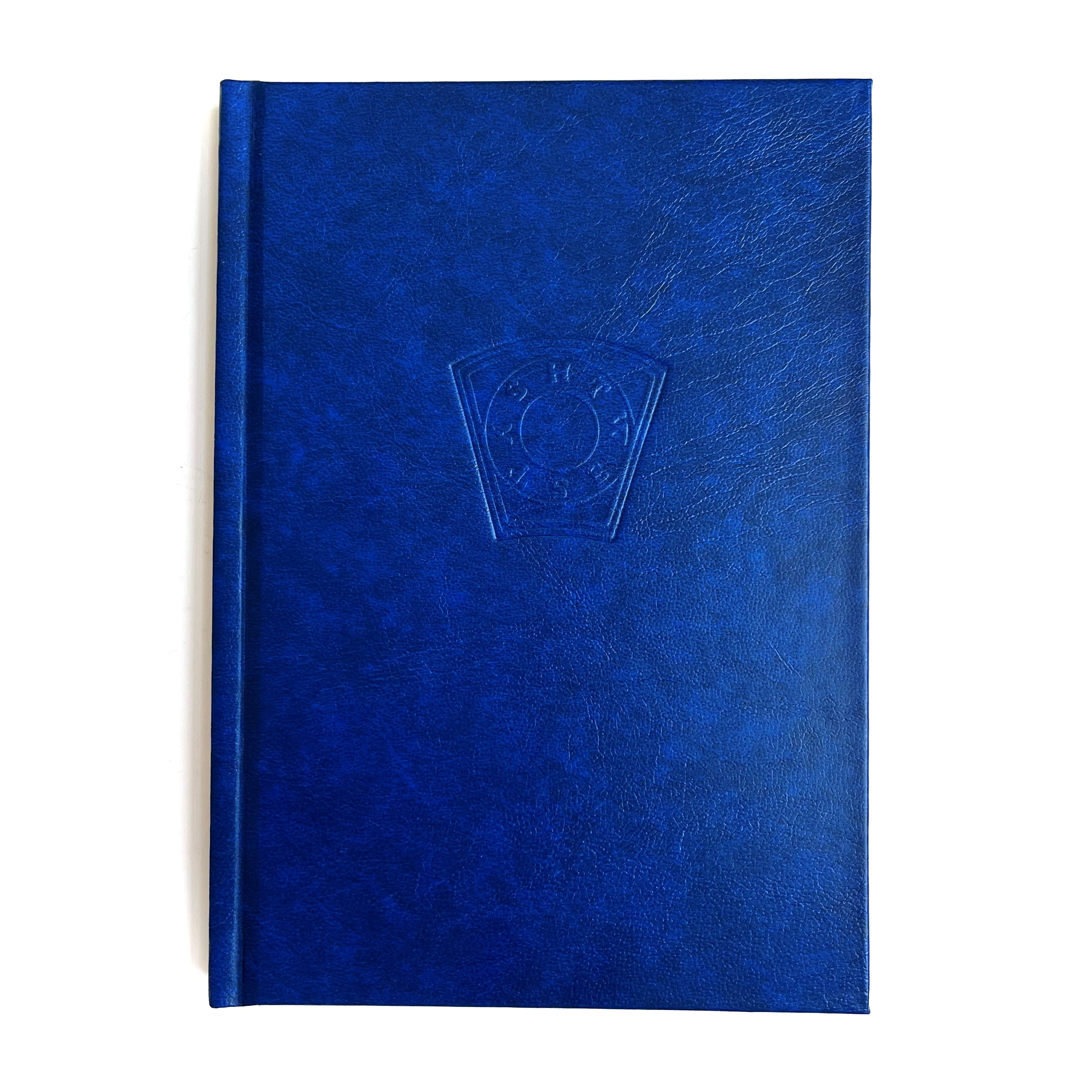 A blue hardback Mark ritual book with embossed detailing on the cover.