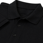 Close up view of olded black polo shirt with a collar and button placket.