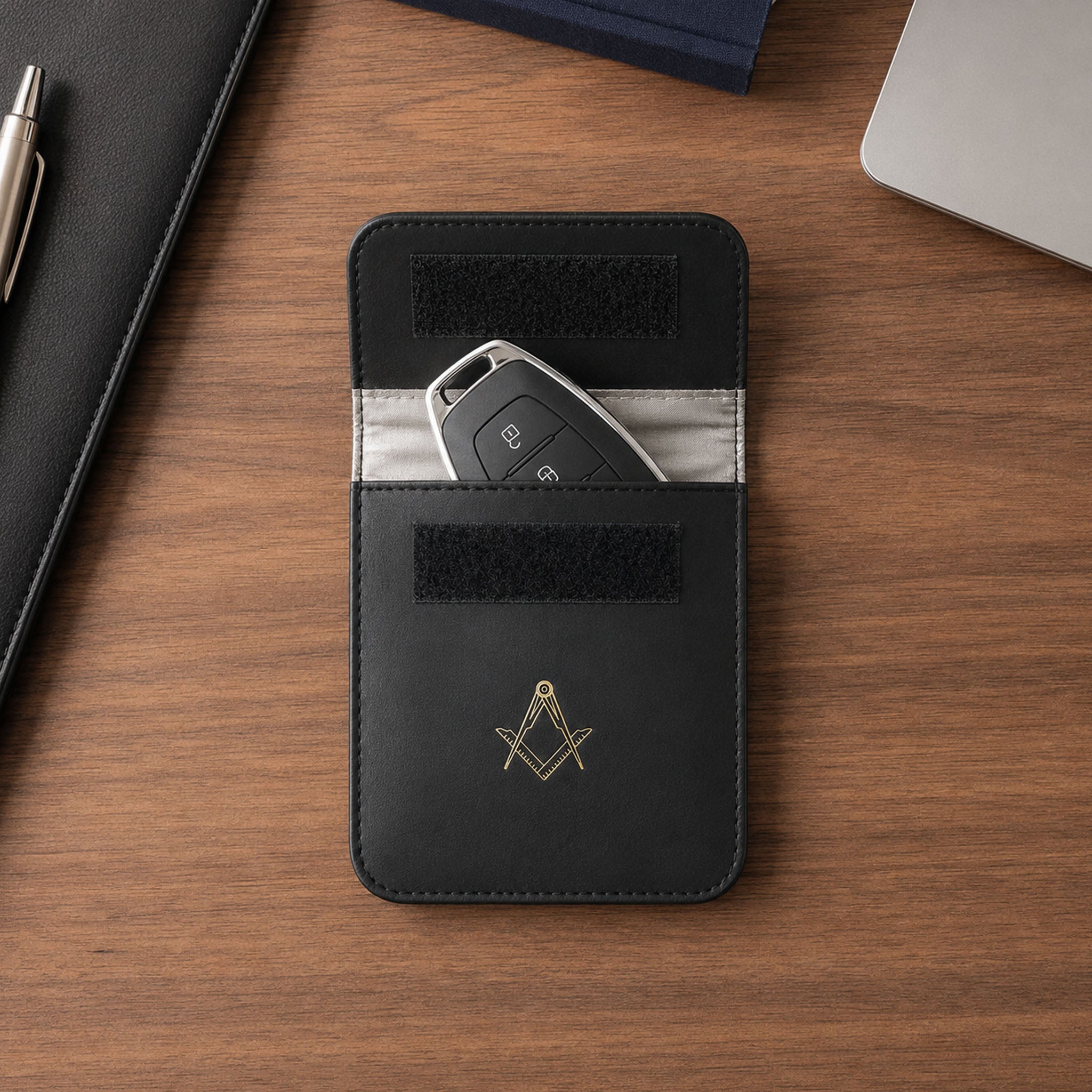 Black leather masonic car key holder on wooden desk