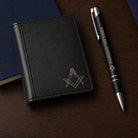 Black Masonic card holder with gold Square and Compasses symbol, displayed with a Freemasons’ Hall London pen.