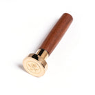 A seal with a rose motif in gilt metal affixed to a sturdy wooden handle.