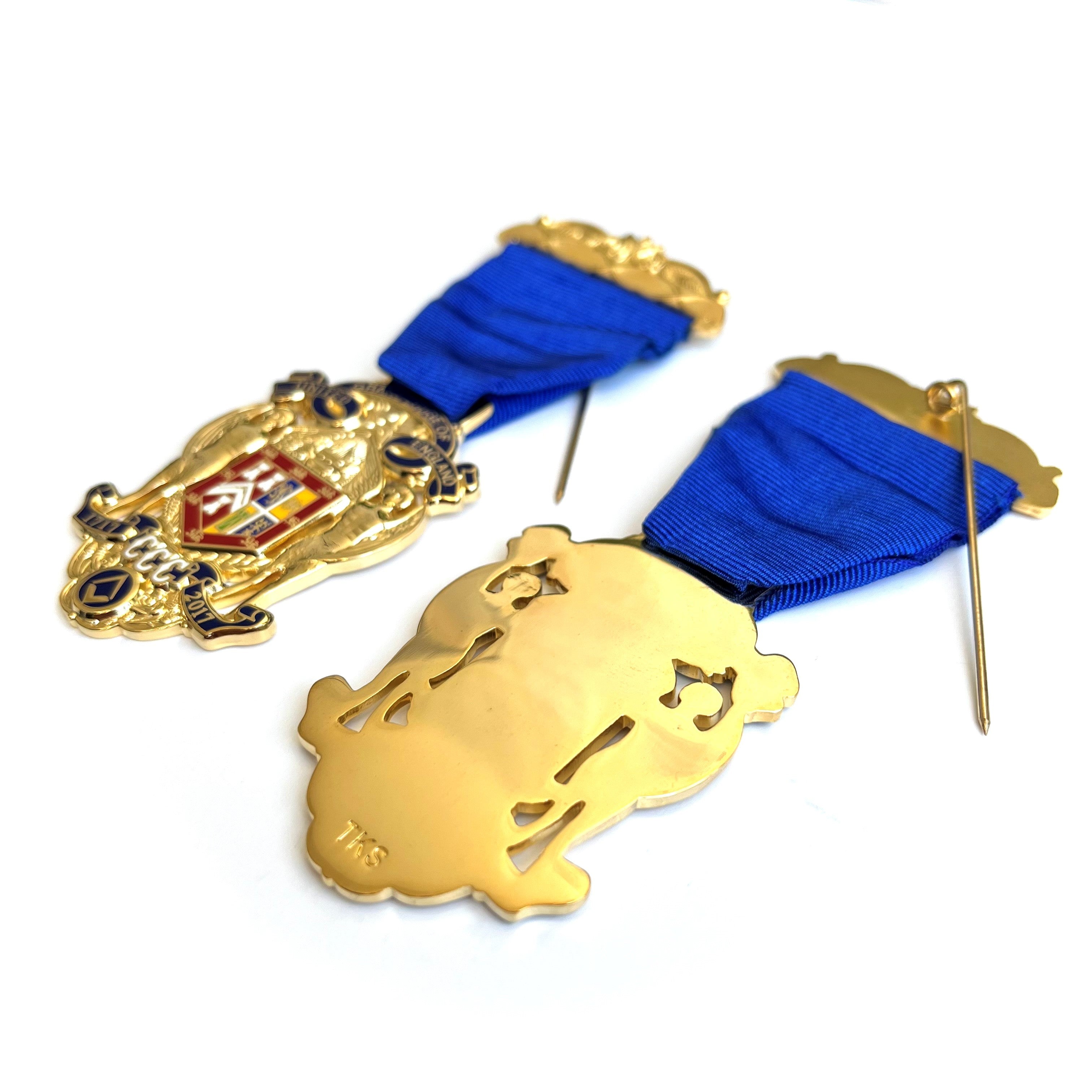 Masonic Tercentenary Breast Jewel gold coloured jewels pins with blue ribbons on a white background