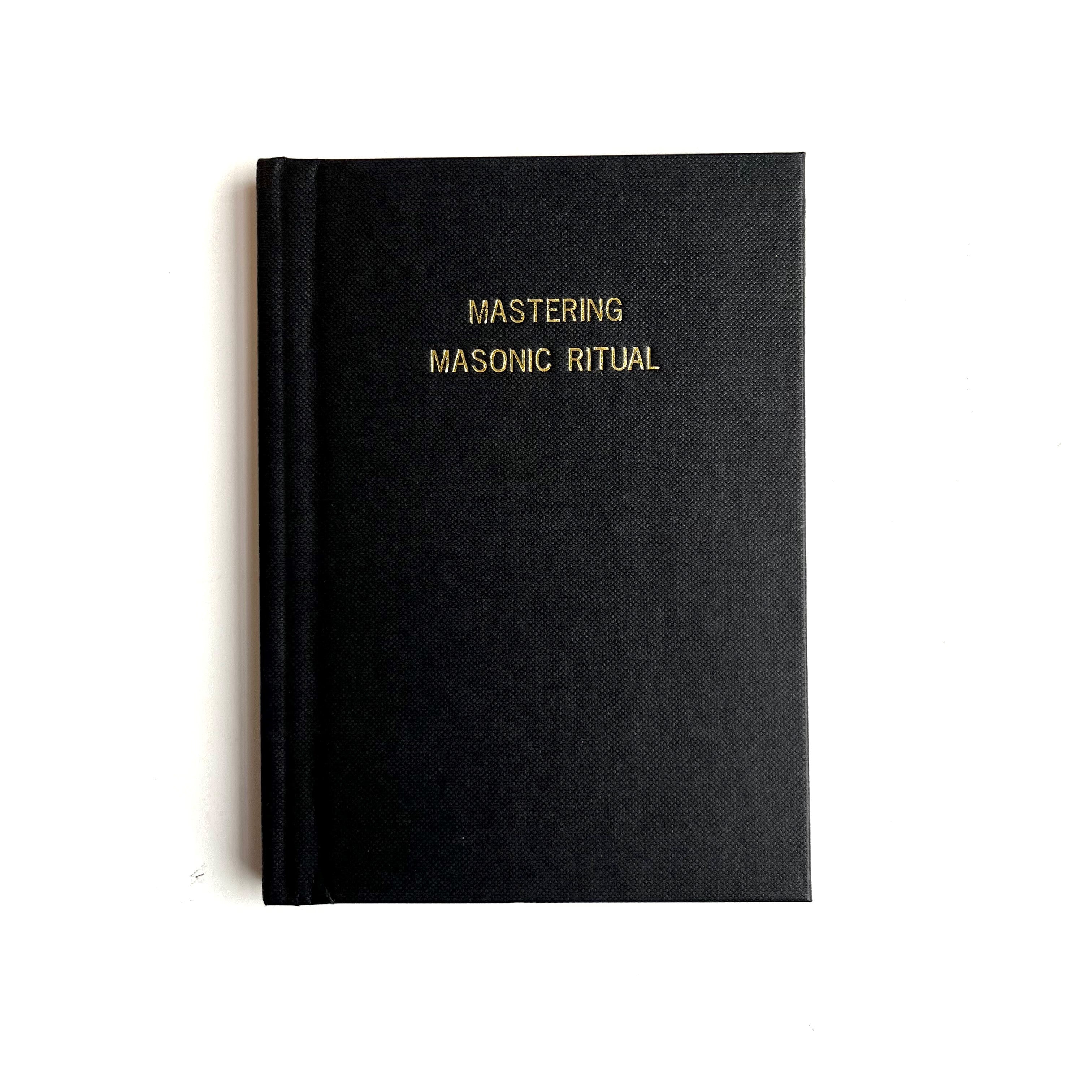 A black book with the title 'MASTERING MASONIC RITUAL' printed in gold lettering on the cover.