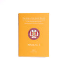 A book titled 'The Order of the Secret Monitor Ritual No 1' with an orange cover, featuring a crest and text.