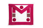 A pink masonic apron with red rosettes and decorative buttons.
