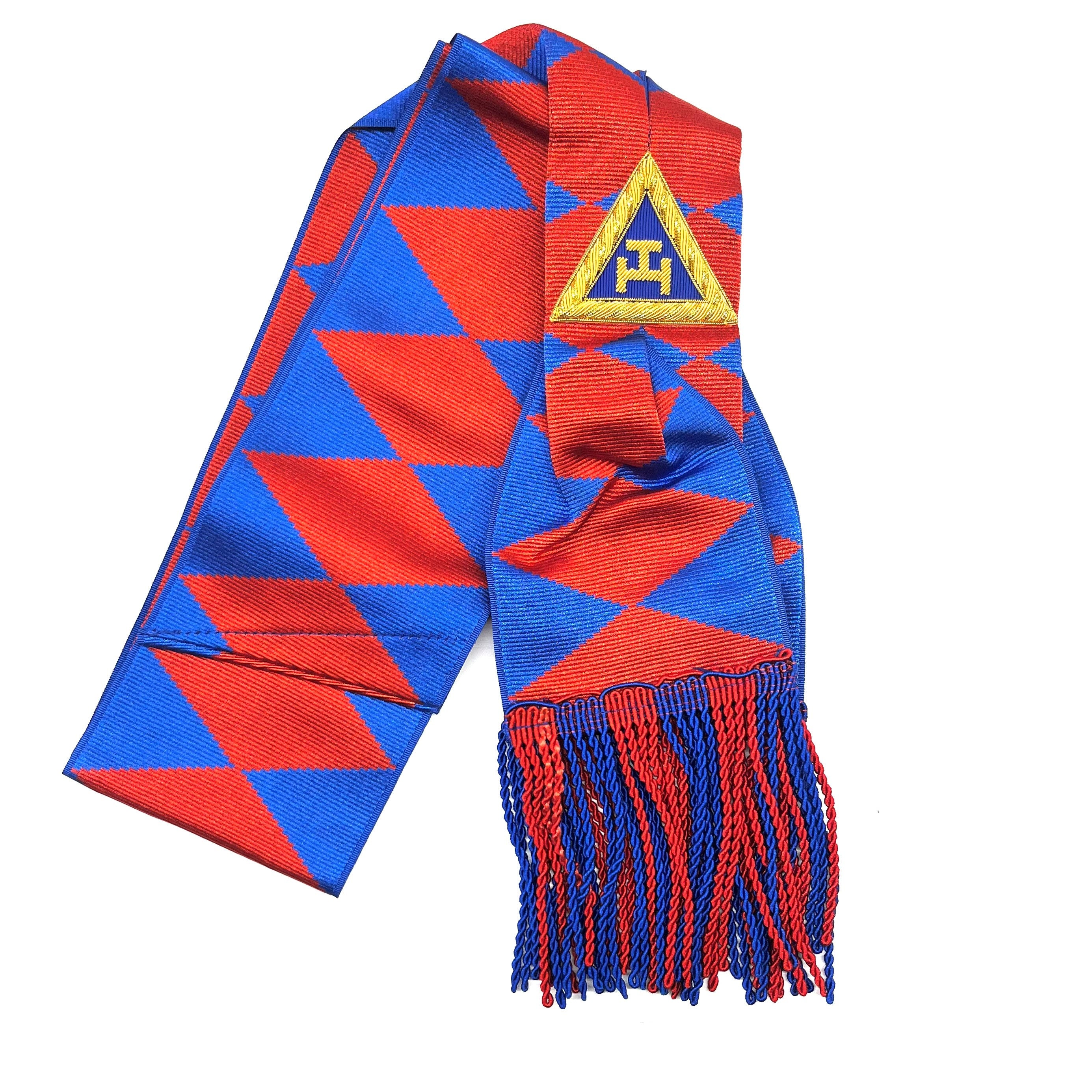 A Masonic sash with blue and red geometric patterns, gold tassels, and a blue triangular badge with a yellow emblem.