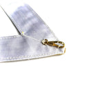 White ribbon with a gold clasp on a white background