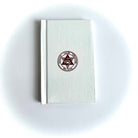 A Masonic Savage Club Royal Arch Ritual closed book with a plain beige cover, featuring a centered emblem or seal on the front.