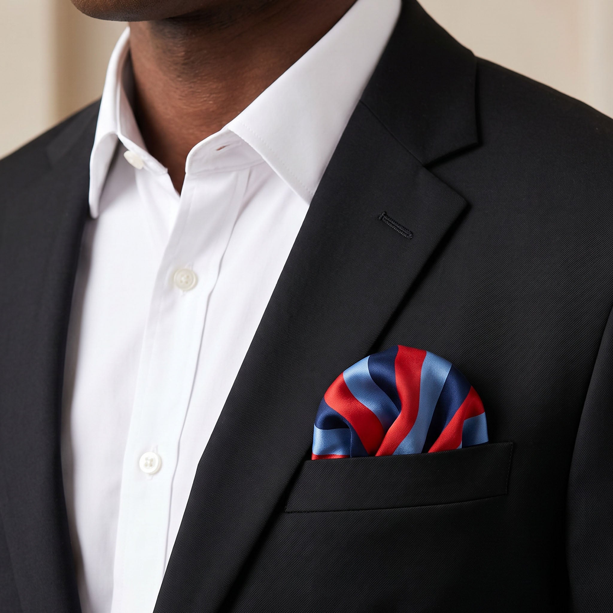 Masonic hankerchief in silk fabric with red, blue, and navy vertical stripes. Being worn in the front suit jacket pocket.