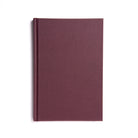 A closed hardback book with a plain maroon cover, titled 'Taylors Pocket Ritual'.