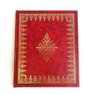 A red hardcover book with gold embossed floral patterns and text on the cover.