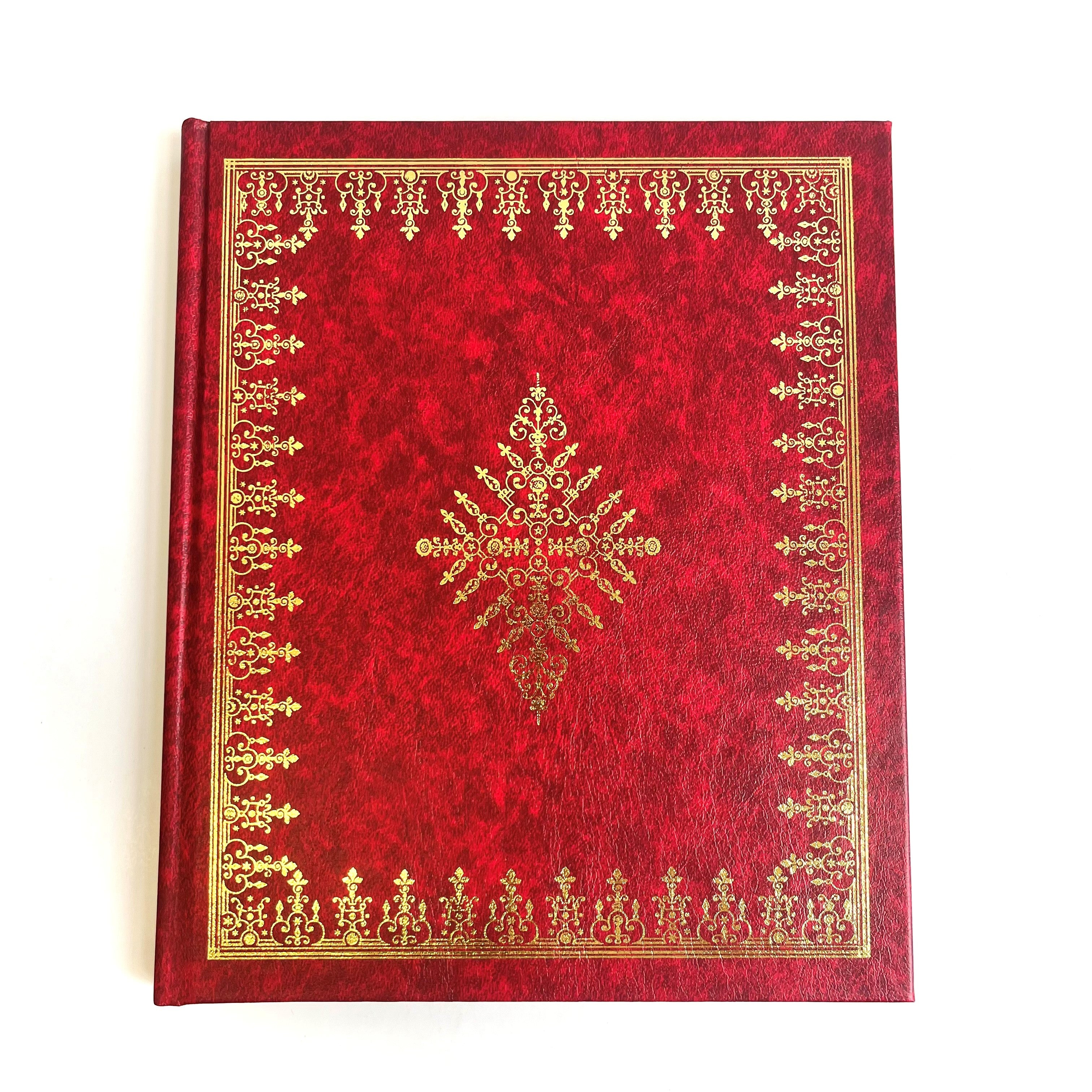 A red hardcover book with gold embossed floral patterns and text on the cover.