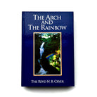 A book cover of 'The Arch and The Rainbow' featuring a blue background with an image of a waterfall and rainbow in the foreground, with the author's name at the bottom.