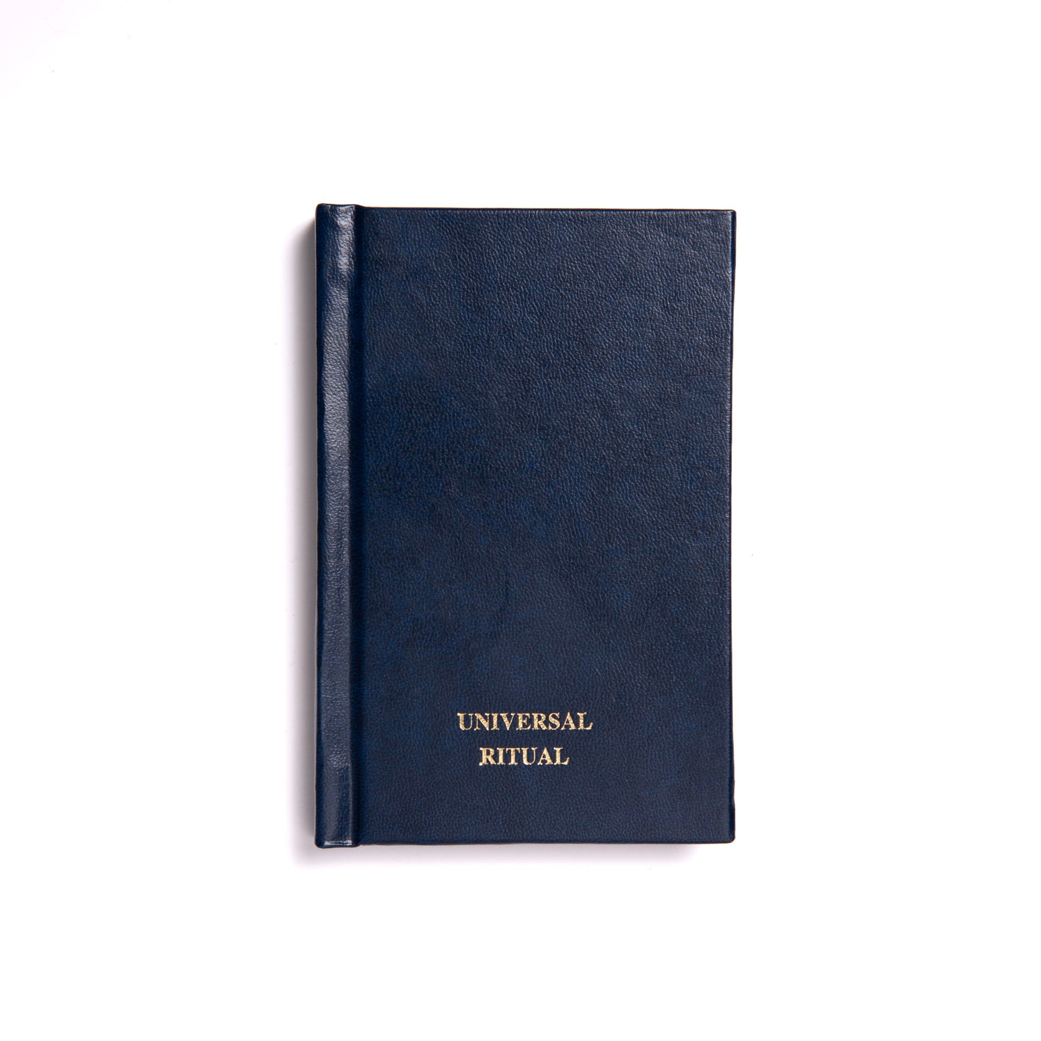 A closed navy-colored book with the title 'UNIVERSAL RITUAL' embossed on the cover.