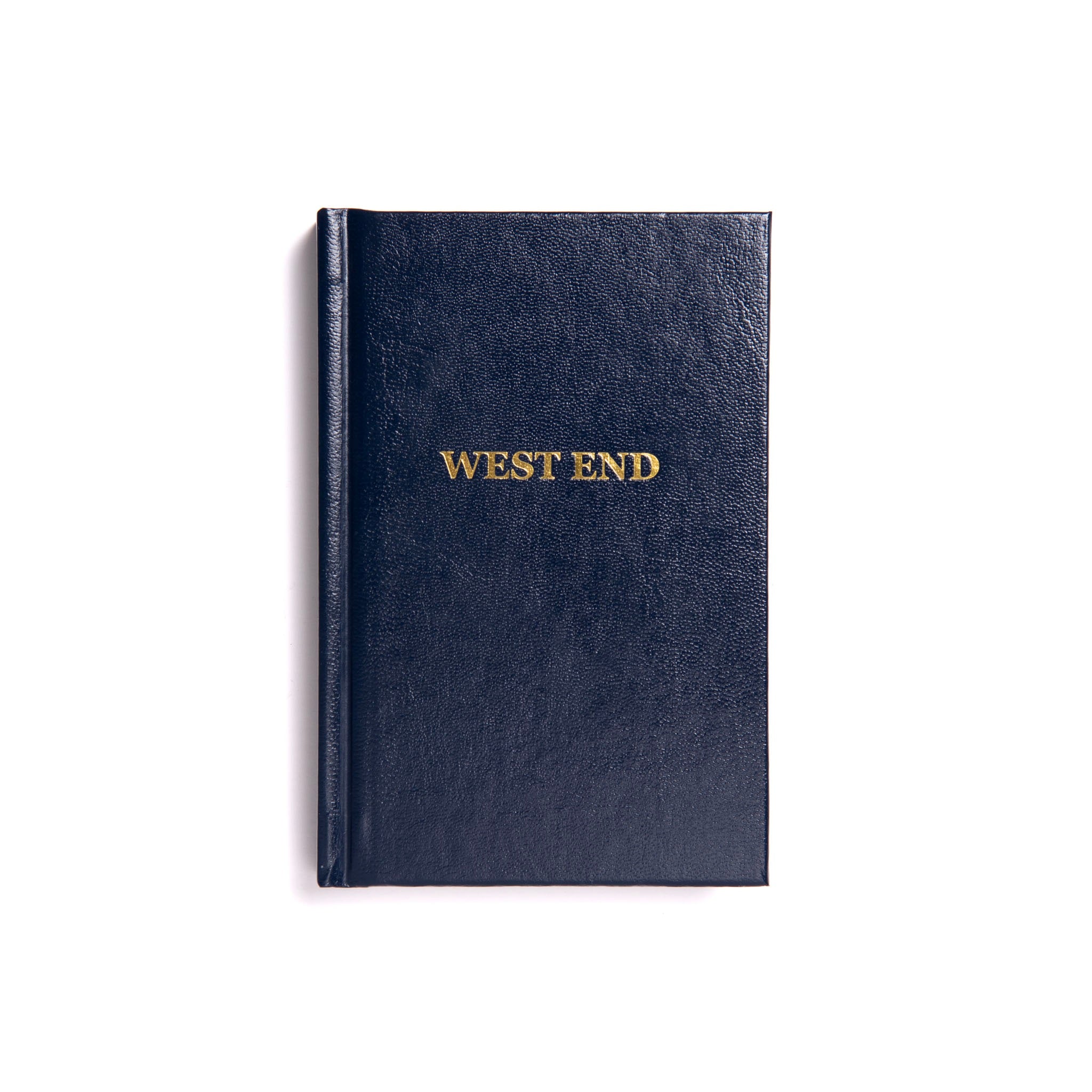 A Masonic West End Ritual closed book with a navy blue cover, titled 'WEST END' in gold lettering on the front.
